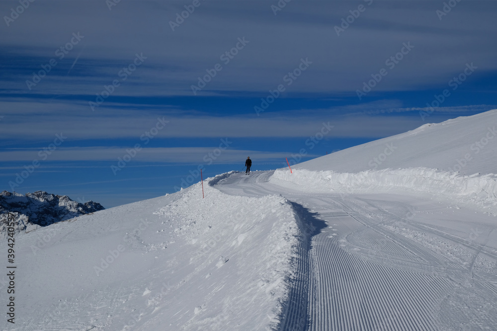 Silhouette of single skier on freshly groomed ski run on the slope on Monte Elmo / Helm, Sexten Dolomites, Italy