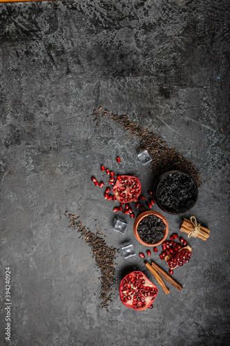 Top view or flat lay image of hookah tobacco. Hookah ceramic head fulled with aromated molose, pomegranade, blueberry and ice cubes on the grunge black table with smoke. photo