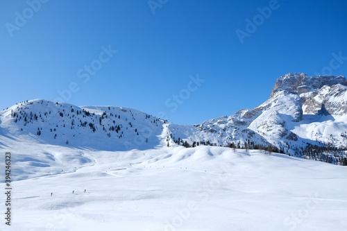 Beautiful winter mountain landscape with cross-country ski tracks and silhouette of running skiers. Piazza Prato plateau  Sexten Dolomites  South Tyrol  Italy