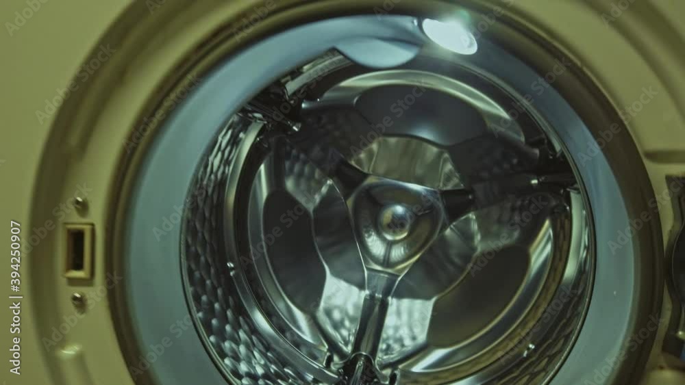 Opening the door of old laundromat and getting inside the shiny metal drum. Opening the door of old laundromat and getting inside the shiny metal drum.