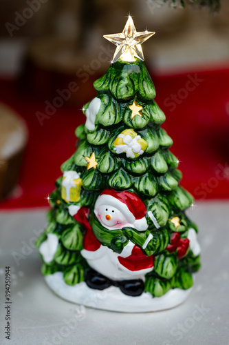 Santa Claus and Christmas tree flashes toy on blurred background. Merry Christmas and Happy new Year. Cute Santa Claus toy close up, copy space for text. Traditional santa claus