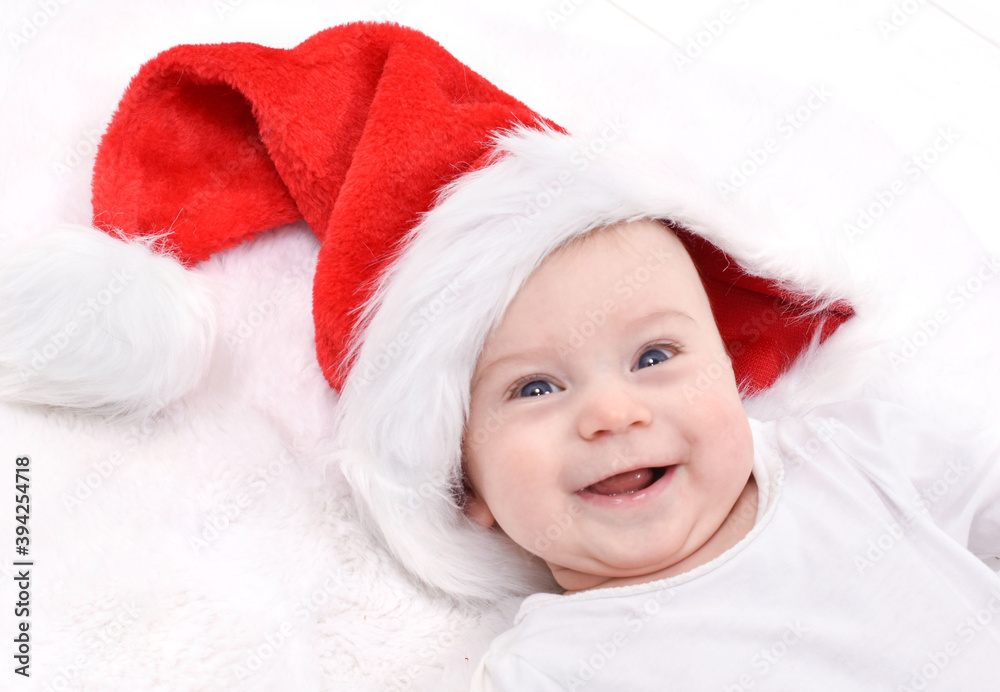Christmas mood. Cute four month old caucasian baby in a Santa Claus hat laughing, looking at camera. Christmas mood. Cute four month old caucasian baby in a Santa Claus hat laughing, looking at camera.