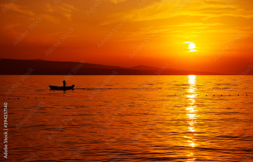 Image of a fishing boat against the sunset background