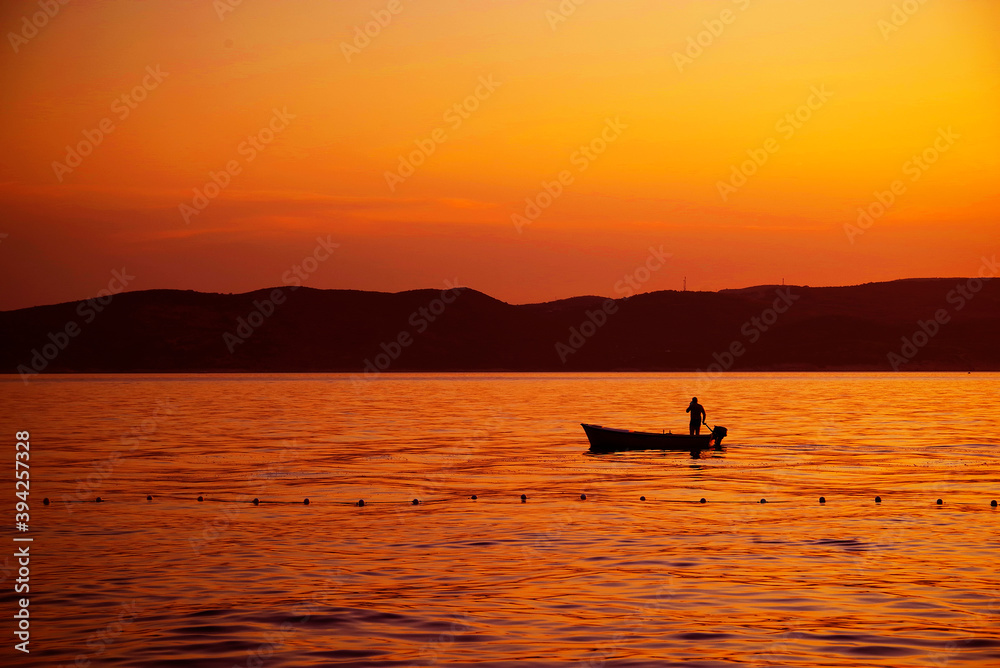 Image of a fishing boat against the sunset background