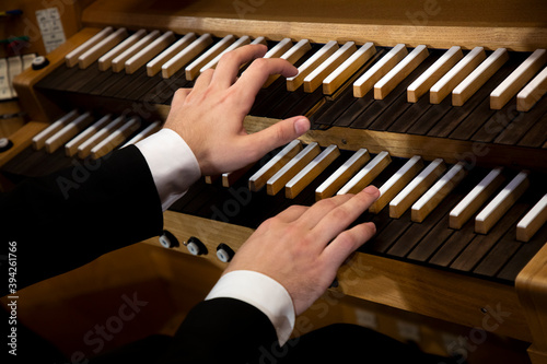 Close up view of a organist hands playing a pipe organ photo