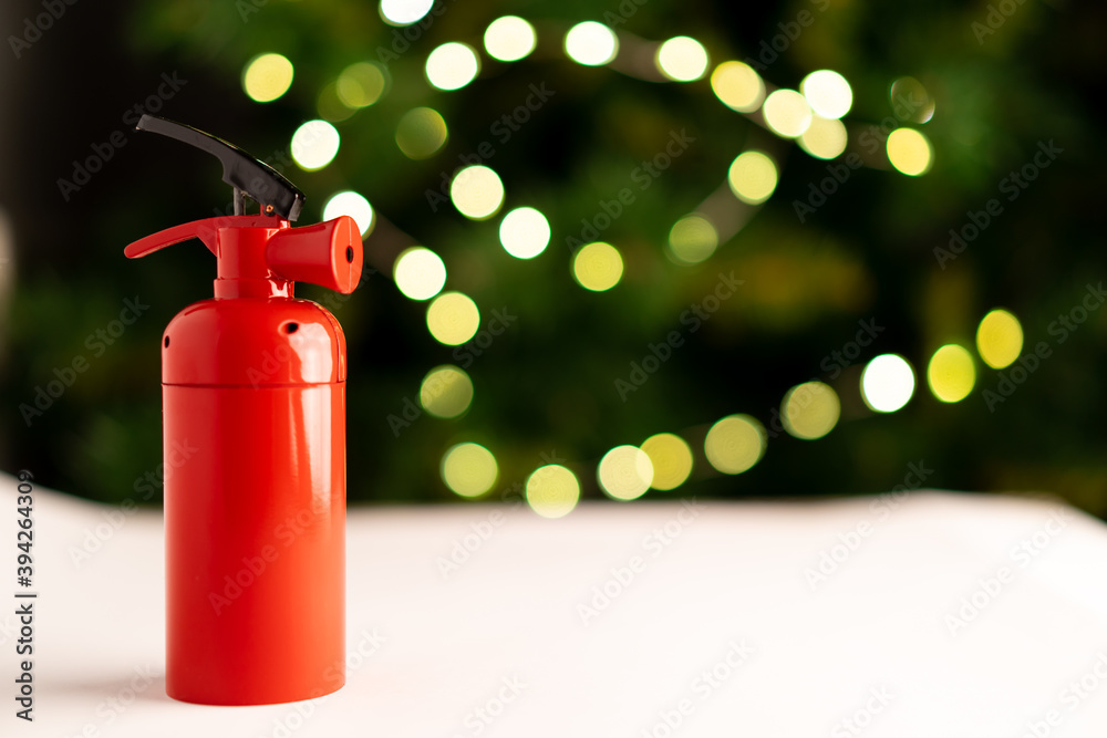 The fire extinguisher stands on a white table, against the background