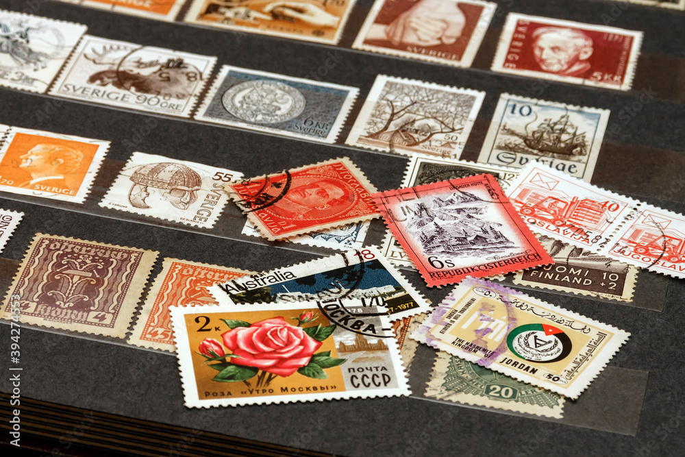 Various old postage stamps from various countries in the philatelic album