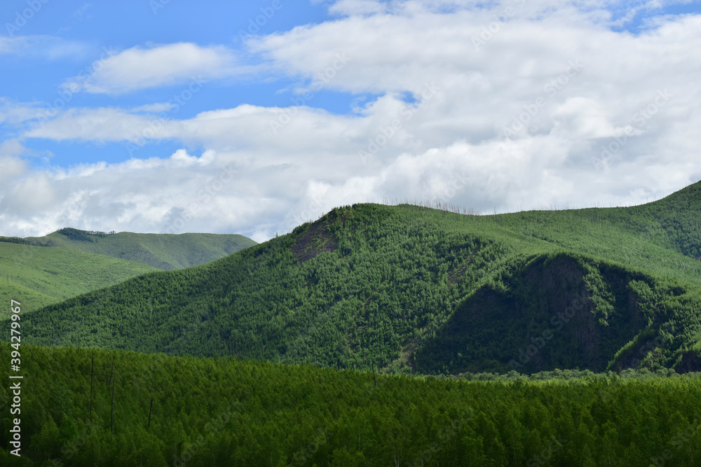 Green hills and blue sky with white clouds. Sikhote-Alin mountains. Green hills and blue sky with white clouds. Sikhote-Alin mountains.