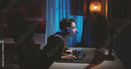 Teenage boy wearing headphones playing an online computer game, communicating with players.
His headphones out the battery, he checks what's wrong with them. photo