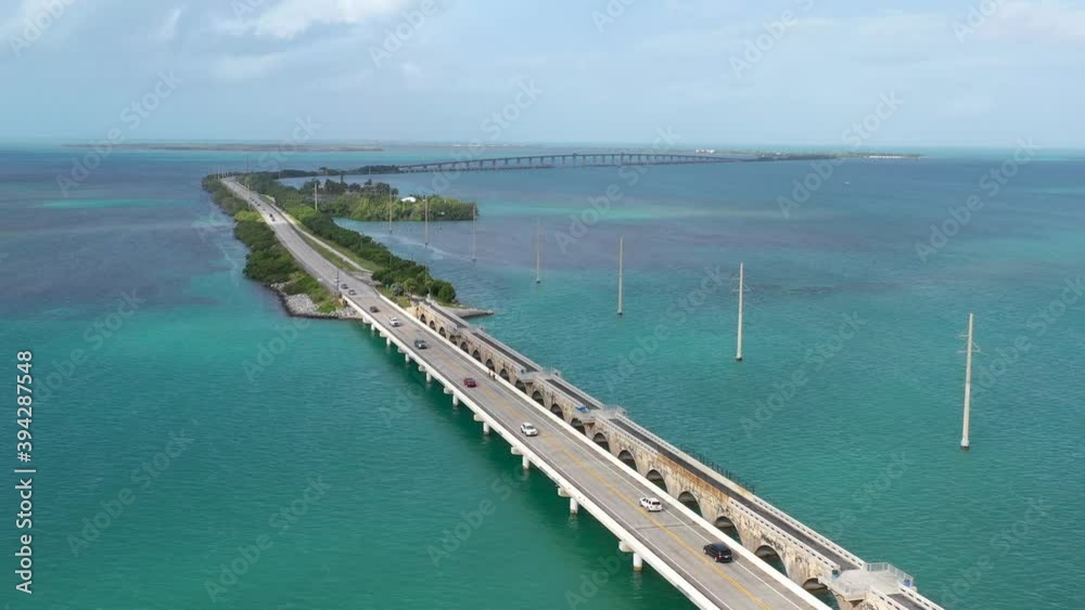 Aerial morning view getting close to cars on the highway passing over the US1 seven mile long bridge over the sea towards the Miami Keys Florida Aerial morning view getting close to cars on the highway passing over the US1 seven mile long bridge over the sea towards the Miami Keys Florida