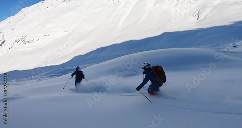 Two Professional skier skiing deep snow. Freeride skiing in Ischgl. Offpist with fresh snow on ski's. Ischgl Tirol Austria photo
