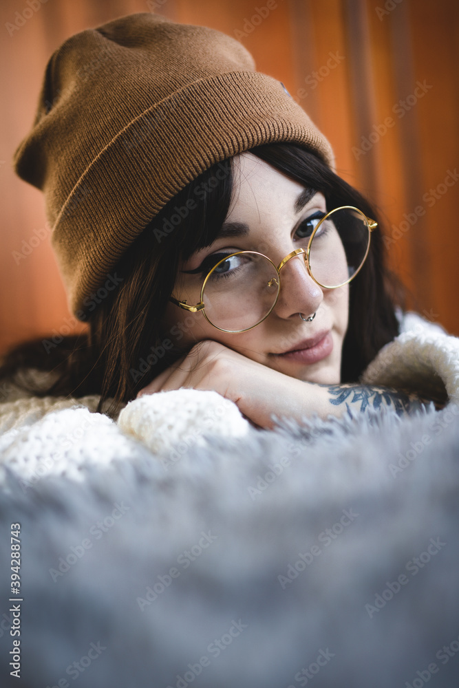 Foto de Mujer caucásica joven, guapa, con gorro de lana marrón, sueter de  lana, gafas redondas, pelo moreno, en un fondo blanco aislado do Stock