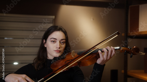 Beautiful and simple wooden violin in the hands of a girl, instrument learning concept