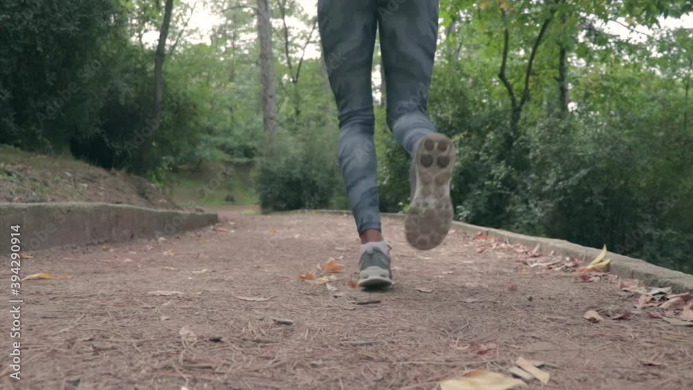 Girl heating up and running on a small path in a park slow motion. Athlete jogging. Girl heating up and running on a small path in a park slow motion. Athlete jogging.