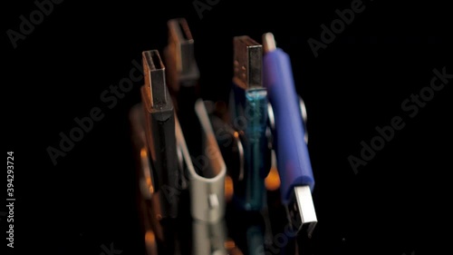Four USB flash drives rotate on isolated black background, Closeup