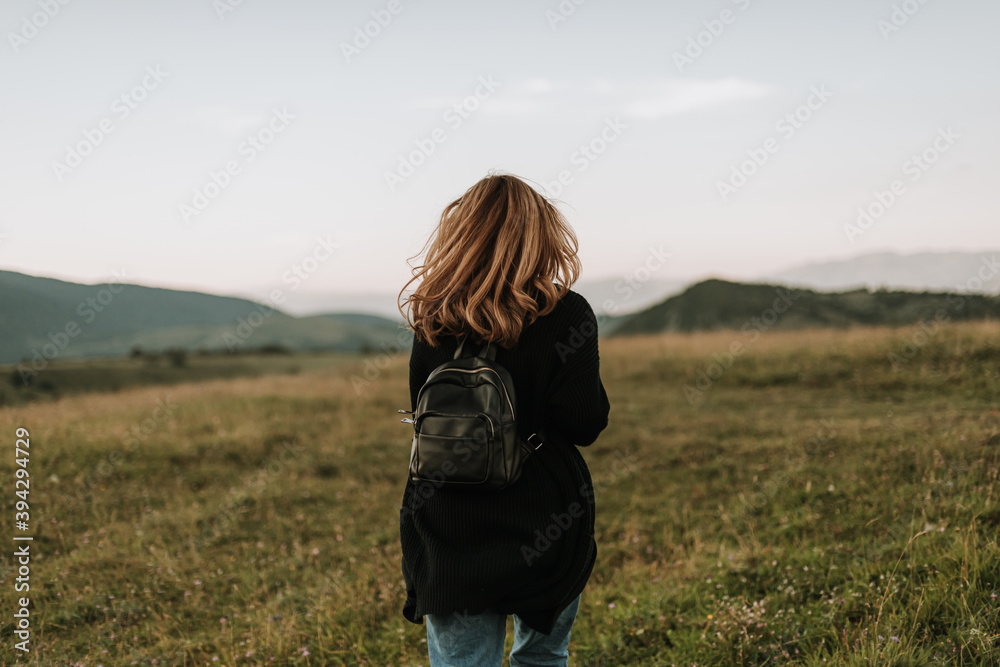 blonde woman with curly hair on wind traveling with backpack blonde woman with curly hair on wind traveling with backpack