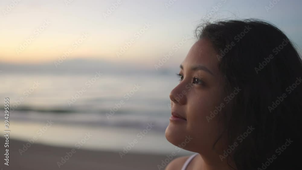 Close up face of Smiling Asian woman looking away to beautiful nature on tropical island beach in summertime at sunrise. Happy woman relax and enjoy outdoor lifestyle in summer holiday vacation. Close up face of Smiling Asian woman looking away to beautiful nature on tropical island beach in summertime at sunrise. Happy woman relax and enjoy outdoor lifestyle in summer holiday vacation.