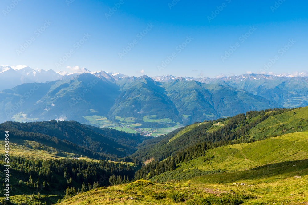 Idyllic landscape with mountain top above green pastures under a blue sky with white clouds high up in the Venediger Alps in summer. salzburg region, austria in europe