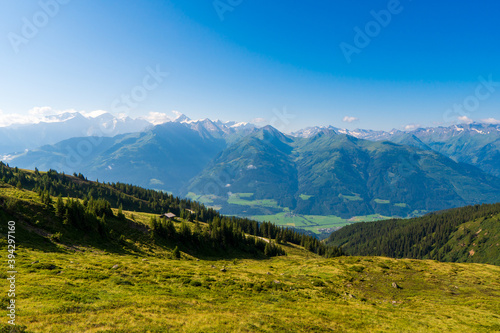 Idyllic landscape with mountain top above green pastures under a blue sky with white clouds high up in the Venediger Alps in summer. salzburg region, austria in europe