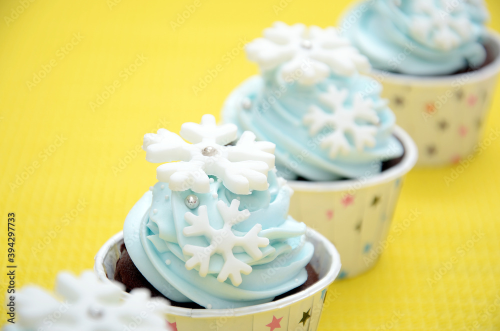 cupcakes with frosting and topping snowflakes, happy nad fun in yellow background