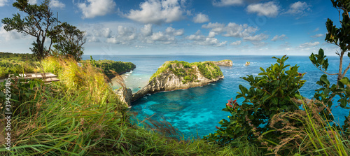Atuh Beach with crystal clear azure water on background mountain landscape and blue summer sky. Bali, Indonesia