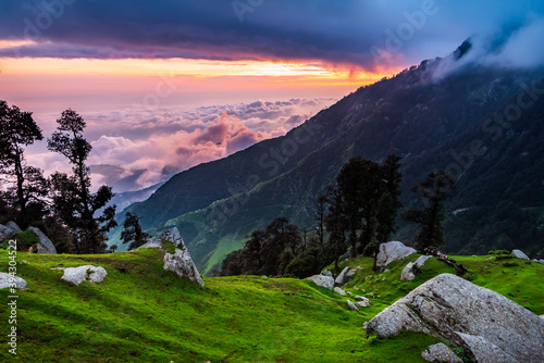 Mesmerizing view of cloudy red sunset sky background during sunset enroute to Triund trekking trail from Mcleodganj, Dhramshala, Himachal Pradesh, India.