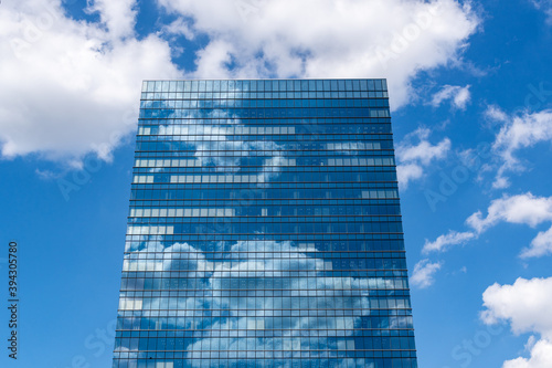 ビルの下から見上げた　晴れた空に流れる雲がビルに映る