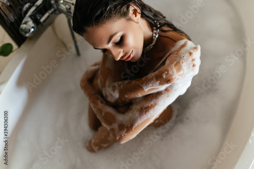 Relaxed young woman laying in bathtub on villa in Bali Indonesia