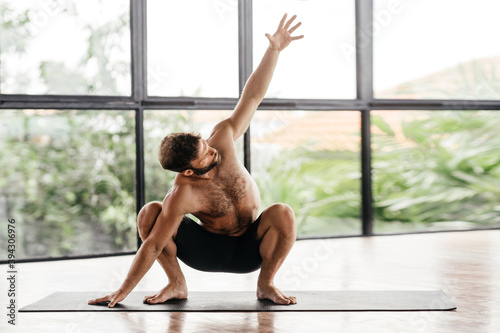 Yoga men workout in studio  training in front of a window