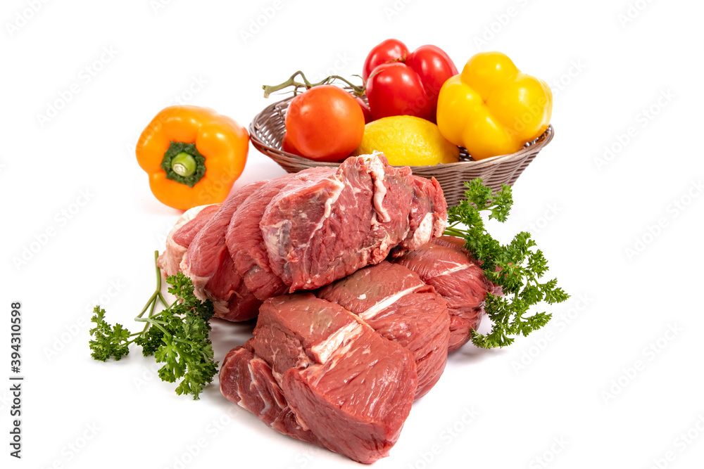 Two pieces of beef sirloin tip roast with a basket of peppers, onions, lemon and tomatoes isolated on white
Two pieces of beef sirloin tip roast with a basket of peppers, onions, lemon and tomatoes isolated on white