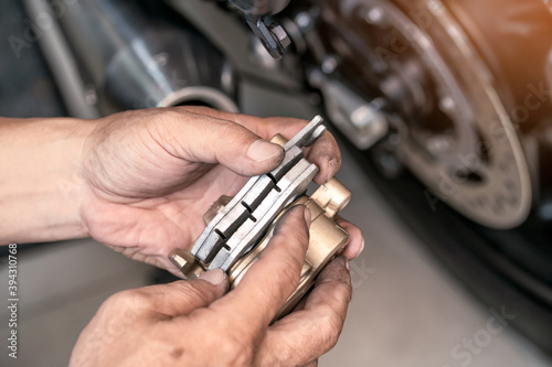 Mechanic check Brake pads, Brake system at motorcycle garage ,motorcycle maintenance and repair concept.selective focus