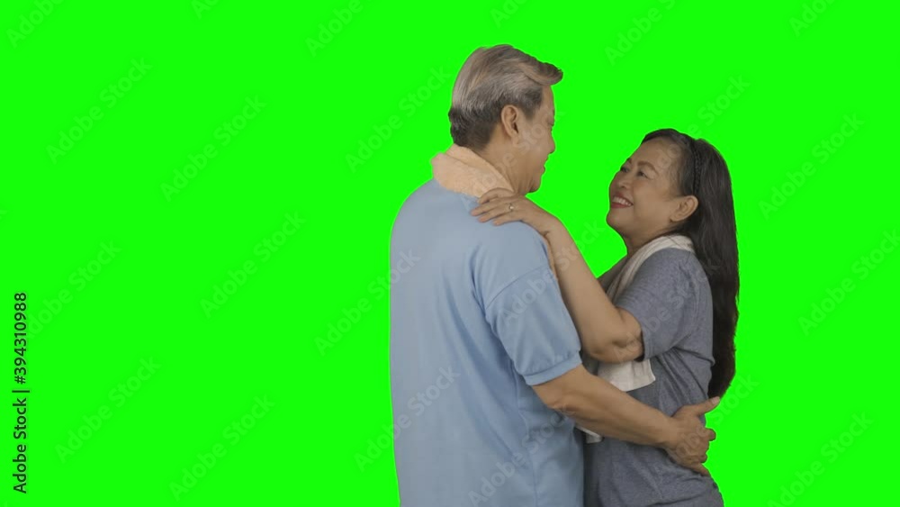 Romantic old couple dancing together while wearing sportswear in the studio with green screen background. Shot in 4k resolution Romantic old couple dancing together while wearing sportswear in the studio with green screen background. Shot in 4k resolution