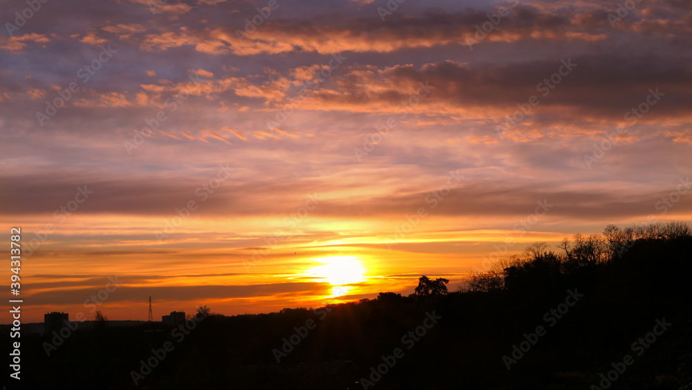 Amazing sunrise in rural scene. Dramatic sky with sunbeam and stratus clouds over the silhouette of hill on the horizon. Amazing sunrise in rural scene. Dramatic sky with sunbeam and stratus clouds over the silhouette of hill on the horizon.