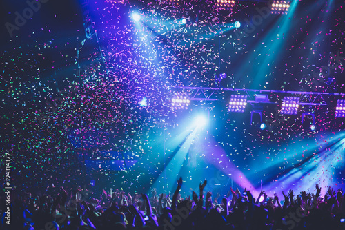 Fotografie A crowded concert hall with scene stage lights, rock show performance, with peop