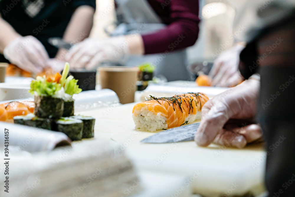 people making sushi on kitchen people making sushi on kitchen