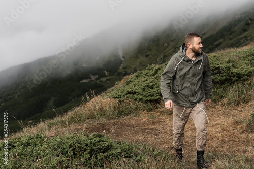 Young male traveler climbs the trail uphill. Tourism concept.