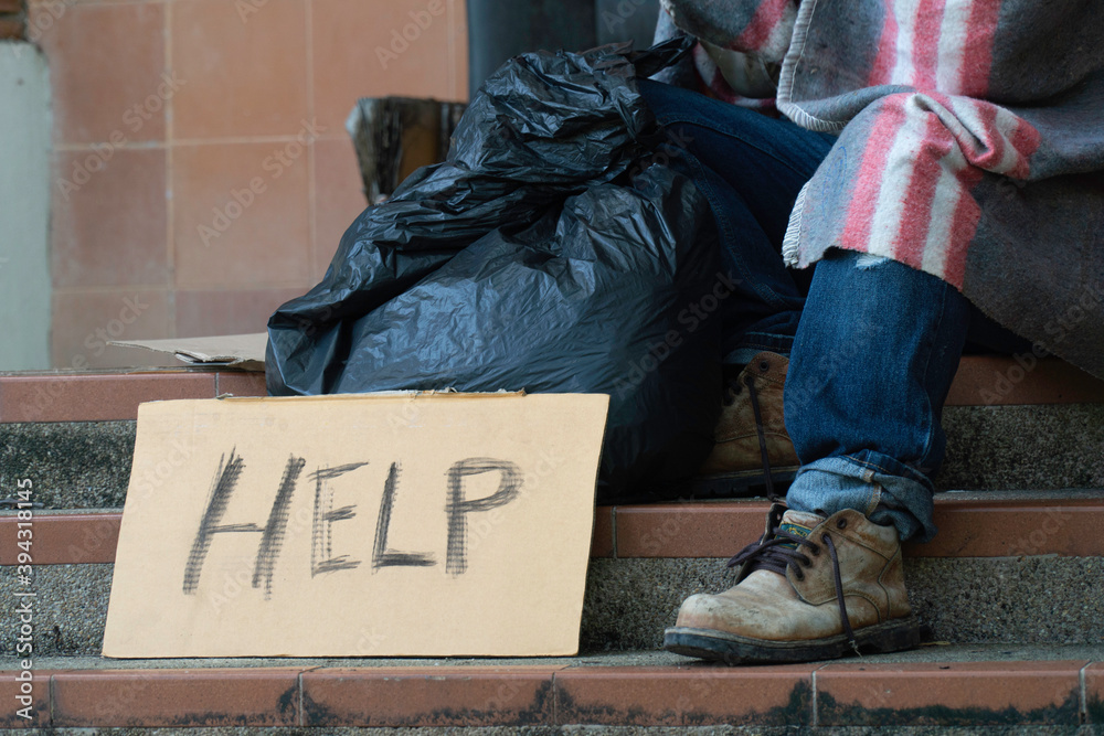 Fototapeta premium Help sign From a homeless man sitting on the side of the road.