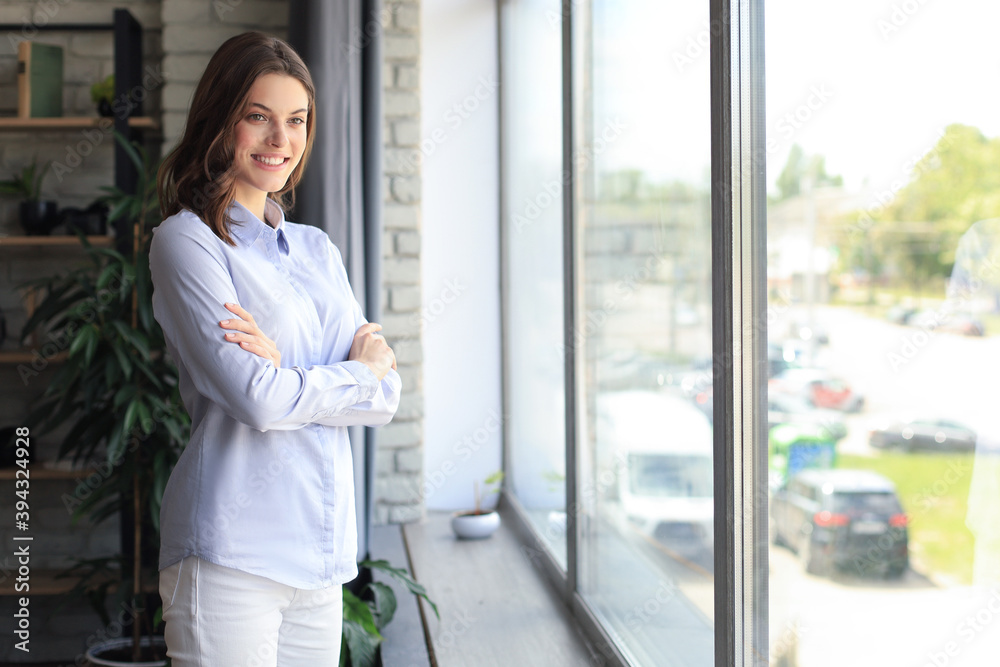 Cheerful woman student professional standing at home in office looking at camera.