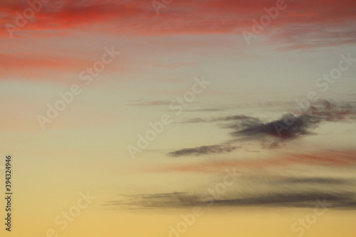 Sun below the horizon and clouds in the fiery dramatic orange sky at sunset or dawn backlit by the sun. Place for text and design