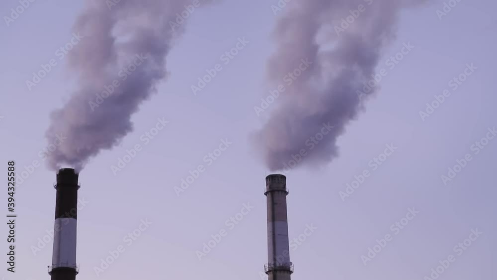 Steam from the pipes of the heating system in season on the background of the lilac evening sky Steam from the pipes of the heating system in season on the background of the lilac evening sky