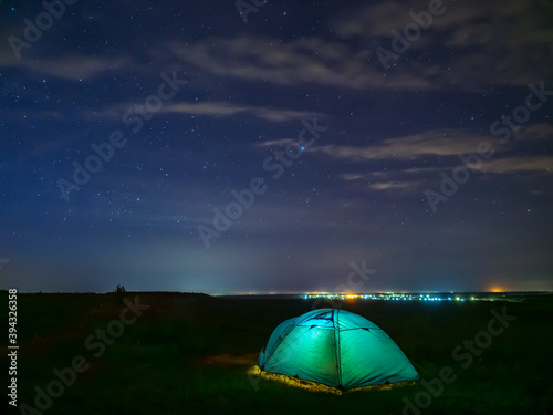 Green tent under stars sky