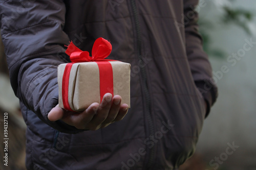 Men's hand holding gift box for his girlfried photo