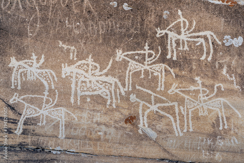 Closeup view of riders on horses carving on rock: antique silk road petroglyphs above Langar village in Wakhan Corridor, Gorno-Badakshan, Tajikistan