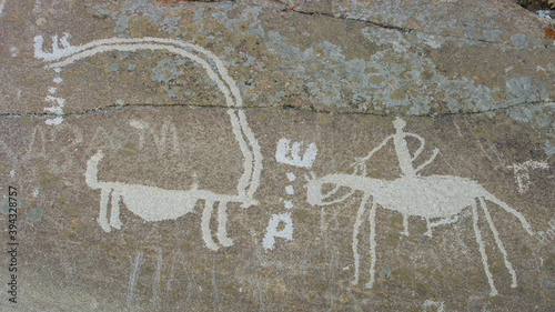 Rider on horse and ibex carving on rock: detail of antique silk road era petroglyphs above Langar in Wakhan Corridor, Gorno-Badakshan, Tajikistan Pamir