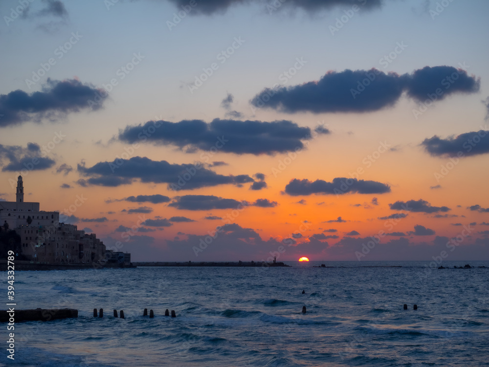 Yafo, Israel - January 15, 2017: Coastal view of the ancient city of Yafo or Jaffanear Tel Aviv, Israel. Cityscape in sunset hour with clouds in the sky.