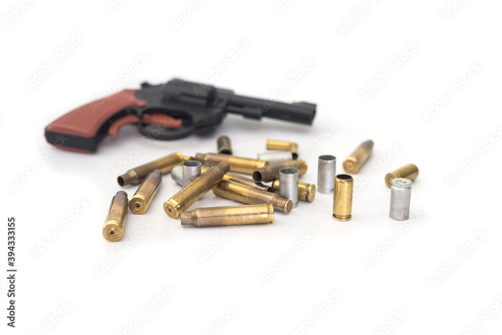 Empty cartridges and a toy gun on a white background.
