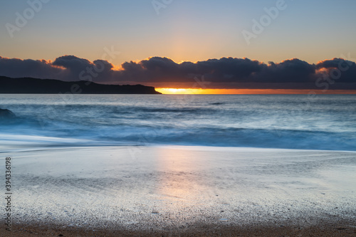 Sunrise by the sea with cloud bank on the horizon