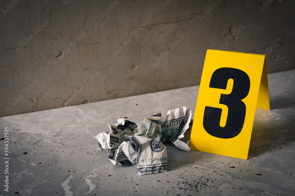 Crime scene marker and crumpled dollars on light grey marble table ...