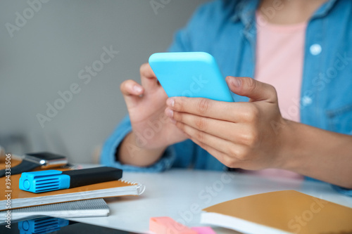 Close-up view of young student using smartphone app.