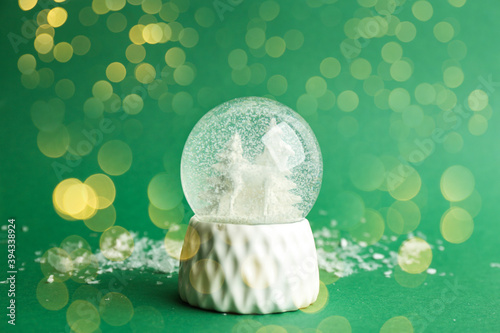 Beautiful Christmas snow globe on green background  bokeh effect